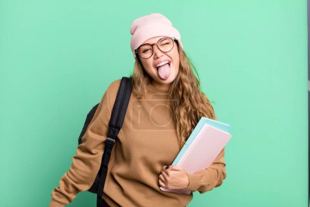 Photo for Hispanic pretty woman with cheerful and rebellious attitude, joking and sticking tongue out. university student concept - Royalty Free Image