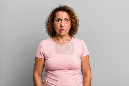 Foto de Mujer hispana de mediana edad sintiéndose despistada, confundida e incierta sobre qué opción elegir, tratando de resolver el problema - Imagen libre de derechos