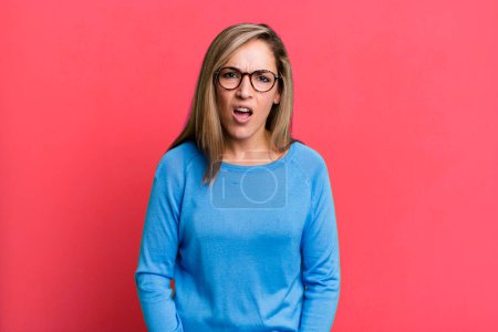 Photo for Blonde adult woman looking shocked, angry, annoyed or disappointed, open mouthed and furious - Royalty Free Image