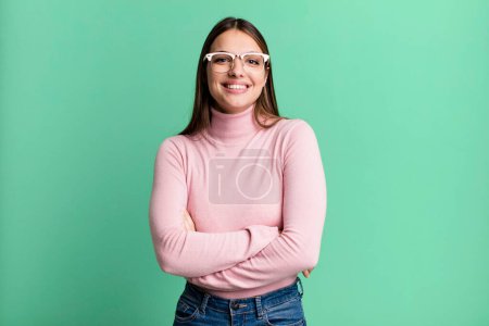 Téléchargez les photos : Pretty young adult woman looking like a happy, proud and satisfied achiever smiling with arms crossed - en image libre de droit