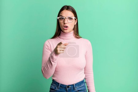Photo for Pretty young adult woman pointing at camera with an angry aggressive expression looking like a furious, crazy boss - Royalty Free Image