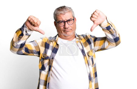 Photo for Middle age senior man looking sad, disappointed or angry, showing thumbs down in disagreement, feeling frustrated - Royalty Free Image