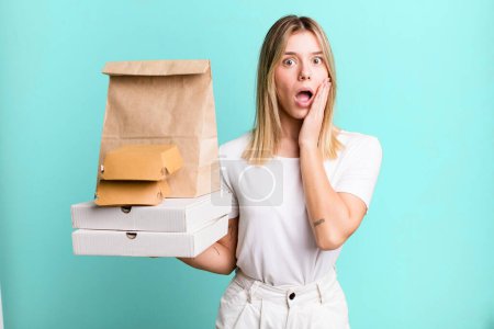 Téléchargez les photos : Young pretty woman feeling shocked and scared. delivery and take away food concept - en image libre de droit