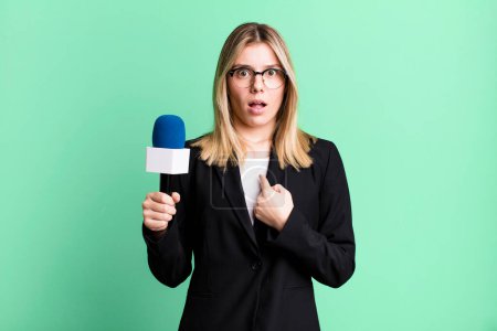 Photo for Young pretty woman looking shocked and surprised with mouth wide open, pointing to self. presenter or journalist concept - Royalty Free Image