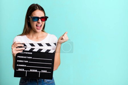 Photo for Young pretty woman shouting aggressively with an angry expression. cinema film or movie concept - Royalty Free Image