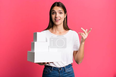 Foto de Joven bonita mujer sintiéndose feliz, sorprendido de darse cuenta de una solución o idea. cajas blancas en blanco - Imagen libre de derechos