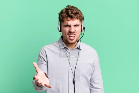 Téléchargez les photos : Young adult caucasian man looking angry, annoyed and frustrated. telemarketer agent concept - en image libre de droit
