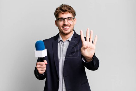 Téléchargez les photos : Young adult caucasian man smiling and looking friendly, showing number four. journalist or presenter with a microphone - en image libre de droit