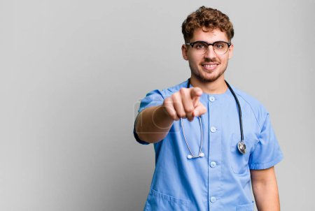 Téléchargez les photos : Young adult caucasian man pointing at camera choosing you. nurse concept - en image libre de droit