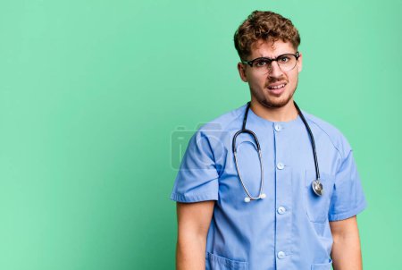 Photo for Young adult caucasian man feeling puzzled and confused. nurse concept - Royalty Free Image