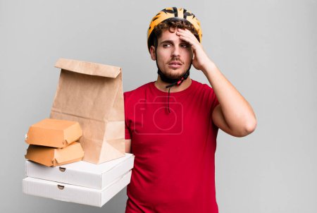 Photo for Young adult caucasian man feeling bored, frustrated and sleepy after a tiresome.  take away fast food deliveryman concept - Royalty Free Image