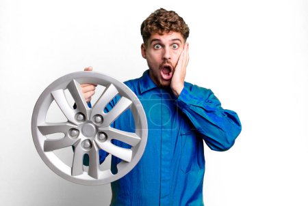 Téléchargez les photos : Young adult caucasian man feeling shocked and scared. car repairman or mechanic concept - en image libre de droit