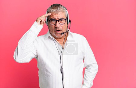 Photo for Middle age senior man looking surprised, realizing a new thought, idea or concept. telemarketer or client attention agent concept - Royalty Free Image