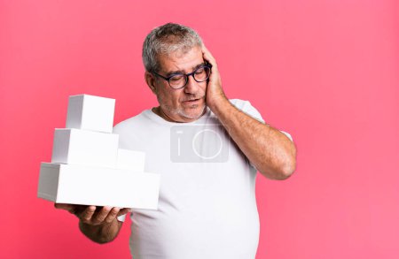 Téléchargez les photos : Homme âgé d'âge moyen se sentir ennuyé, frustré et somnolent après un fatigant. différents paquets boîtes vides - en image libre de droit