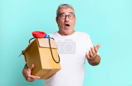 Téléchargez les photos : Homme âgé d'âge moyen se sentant extrêmement choqué et surpris. femme de ménage réparateur avec un concept de boîte à outils - en image libre de droit