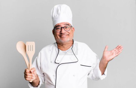 Téléchargez les photos : Homme âgé d'âge moyen se sentant perplexe et confus et douteux. chef de restaurant avec un concept d'outil - en image libre de droit