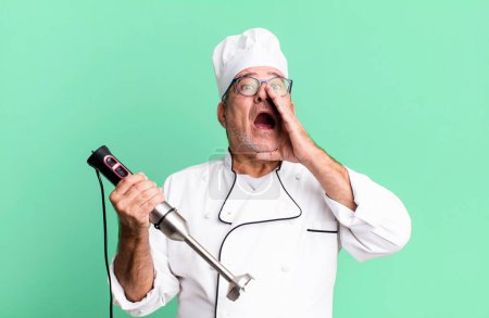 Photo for Middle age senior man feeling happy,giving a big shout out with hands next to mouth. restaurant chef with a tool concept - Royalty Free Image