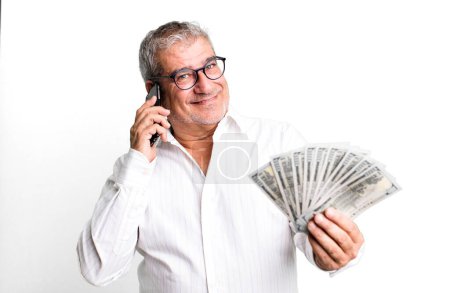 Foto de Hombre mayor de mediana edad con un teléfono inteligente y billetes de dólar - Imagen libre de derechos