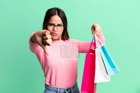 Photo for Hispanic pretty woman feeling cross,showing thumbs down. shopping concept - Royalty Free Image