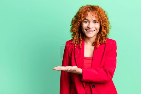 Téléchargez les photos : Cheveux roux jolie femme souriant joyeusement, se sentant heureux et montrant un concept. concept de femme d'affaires - en image libre de droit