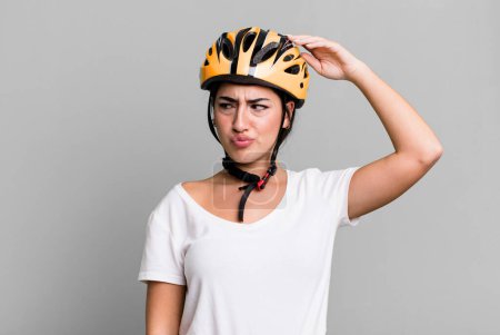 Photo for Smiling happily and daydreaming or doubting. bike helmet concept - Royalty Free Image