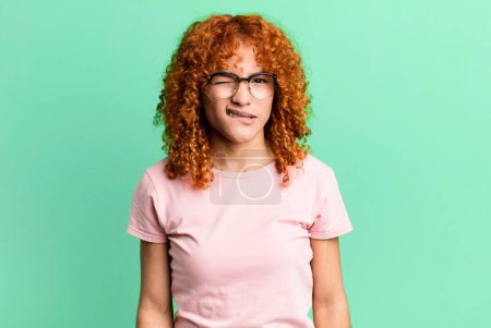 Photo for Redhair pretty woman feeling clueless, confused and uncertain about which option to pick, trying to solve the problem - Royalty Free Image