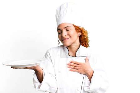 Téléchargez les photos : Red hair pretty chef woman holding an empty dish - en image libre de droit