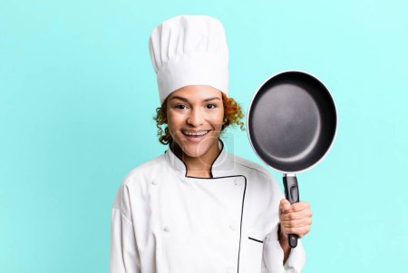 Foto de Pelo rojo bonita mujer chef con una herramienta de sartén - Imagen libre de derechos