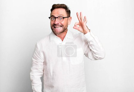 Photo for Feeling successful and satisfied, smiling with mouth wide open, making okay sign with hand - Royalty Free Image