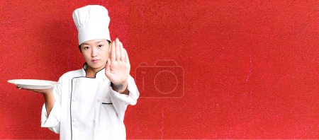 Téléchargez les photos : Jeune adulte jolie femme asiatique. chef restaurant tenant un plat vide - en image libre de droit