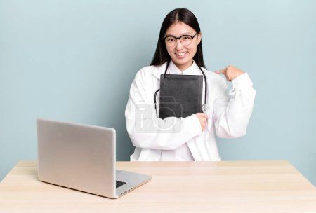 Téléchargez les photos : Jeune adulte jolie asiatique médecin femme sur un bureau avec un ordinateur portable - en image libre de droit