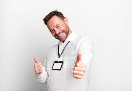 Photo for Middle age man feeling proud,smiling positively with thumbs up. vip pass id accreditation - Royalty Free Image