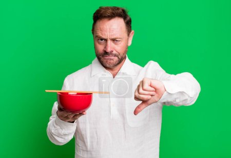 Photo for Middle age man feeling cross,showing thumbs down. breakfast bowl - Royalty Free Image