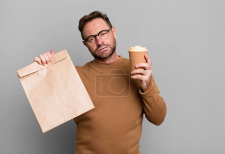 Téléchargez les photos : Homme d'âge moyen avec un café à emporter sport coach concept avec un ballon de football - en image libre de droit