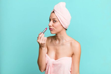 Téléchargez les photos : Young pretty woman making up and holding a lipstick - en image libre de droit