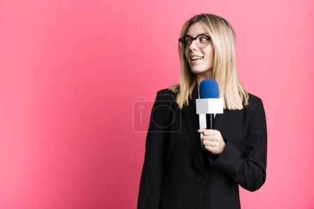 Téléchargez les photos : Jeune jolie journaliste ou présentatrice femme avec un microphone - en image libre de droit