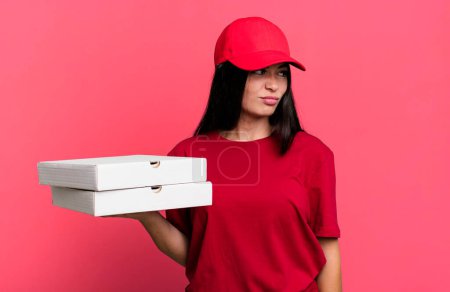 Téléchargez les photos : Hispanic pretty woman feeling sad, upset or angry and looking to the side. delivery pizza concept - en image libre de droit
