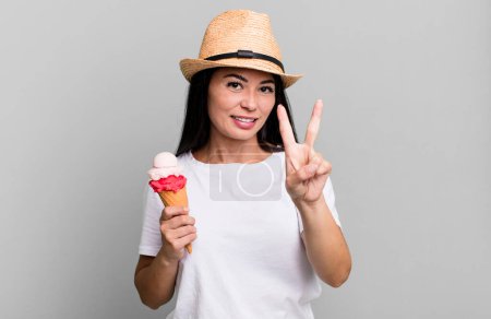 Photo for Hispanic pretty woman smiling and looking friendly, showing number two. ice cream and summer concept - Royalty Free Image