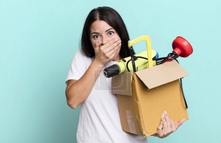 Photo for Hispanic pretty woman covering mouth with hands with a shocked with a tool box - Royalty Free Image