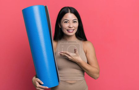 Téléchargez les photos : Hispanique jolie femme souriant joyeusement, se sentant heureux et montrant un concept de yoga concept - en image libre de droit