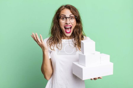 Photo for Hispanic pretty woman feeling happy and astonished at something unbelievable. with white boxes packages - Royalty Free Image