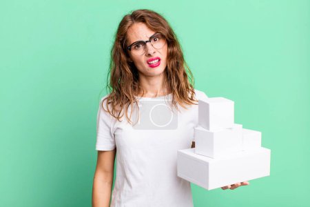 Photo for Hispanic pretty woman feeling puzzled and confused. with white boxes packages - Royalty Free Image