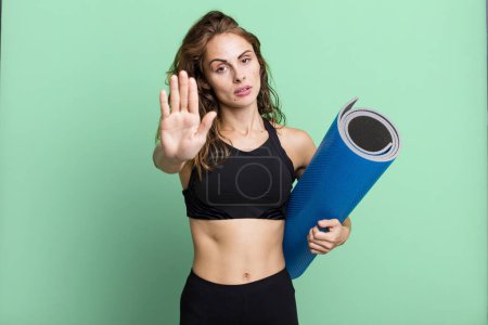 Photo for Hispanic pretty woman looking serious showing open palm making stop gesture. fitness and yoga concept - Royalty Free Image