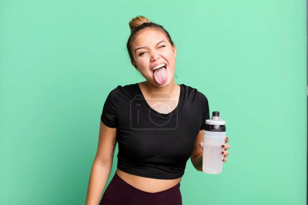 Téléchargez les photos : Hispanic pretty woman with cheerful and rebellious attitude, joking and sticking tongue out. gym and fitness concept - en image libre de droit