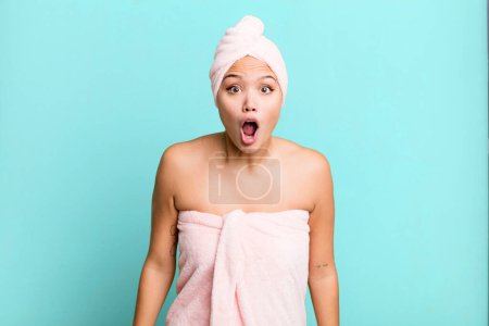 Photo for Hispanic pretty woman looking very shocked or surprised wearing bathrobe. beauty concept - Royalty Free Image