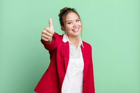 Photo for Hispanic pretty woman feeling proud,smiling positively with thumbs up. business concept - Royalty Free Image
