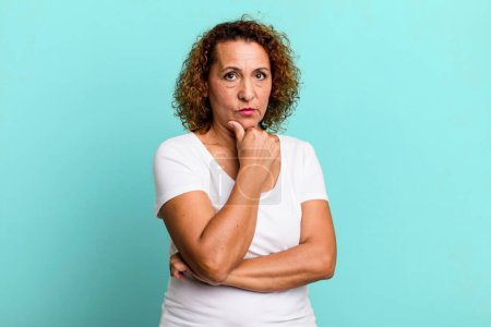 Foto de Mujer hispana de mediana edad que parece seria, confusa, incierta y reflexiva, dudando entre opciones o opciones - Imagen libre de derechos