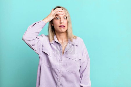Photo for Blonde adult woman panicking over a forgotten deadline, feeling stressed, having to cover up a mess or mistake - Royalty Free Image