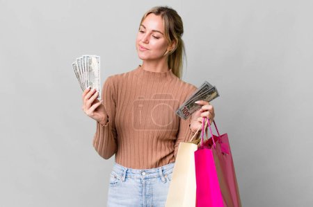 Photo for Pretty caucasian woman with shopping bags and dollar bills - Royalty Free Image