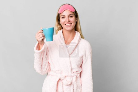 Photo for Pretty caucasian woman wearing night wear and having a coffee cup for breakfast - Royalty Free Image